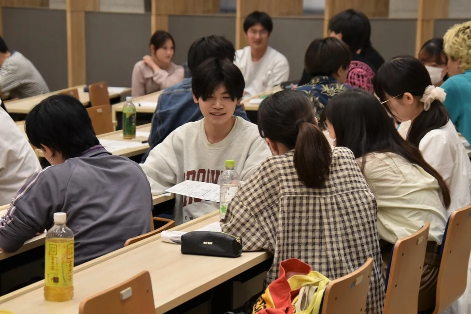 教室または講義室で、多くの学生が机に向かっている様子です。
