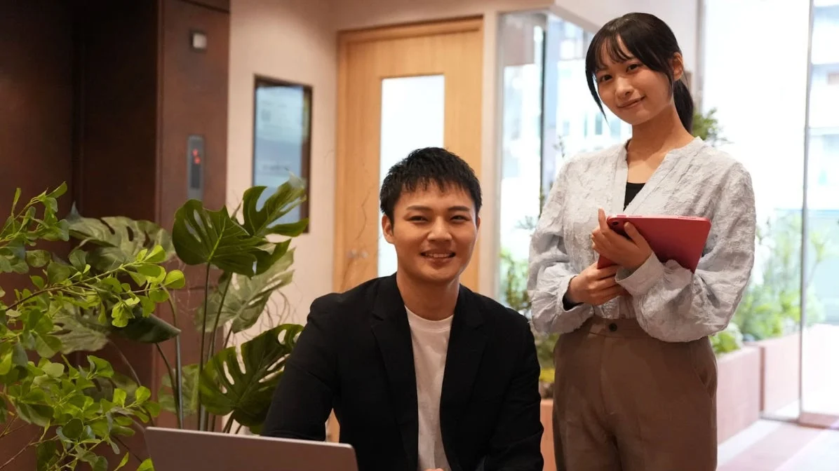 オフィスで笑顔で話すビジネスパーソン