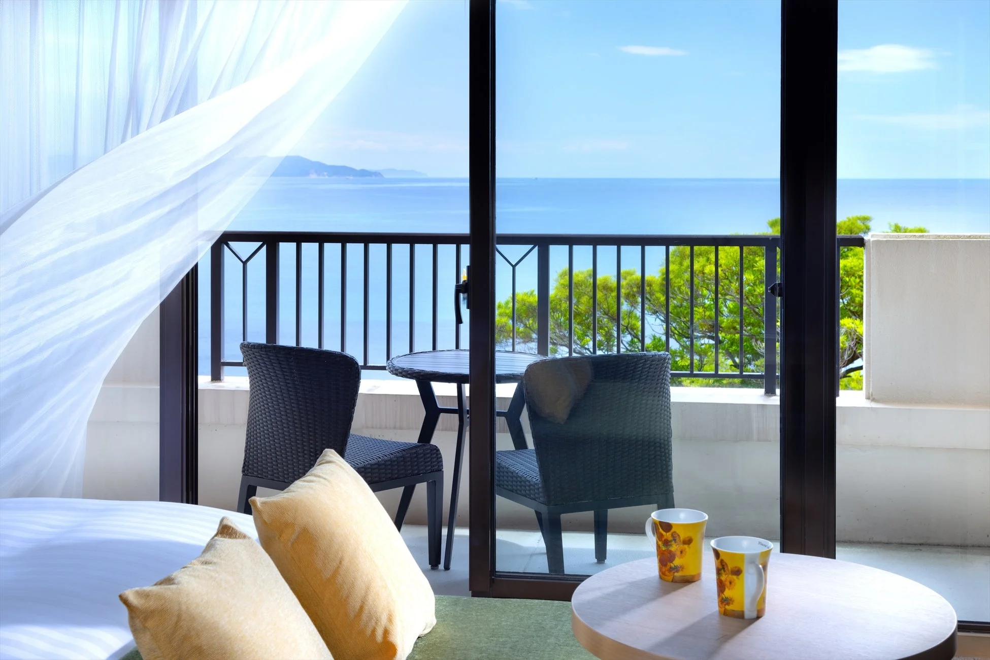 ホテルの客室からバルコニー越しに広がる美しい海の景色