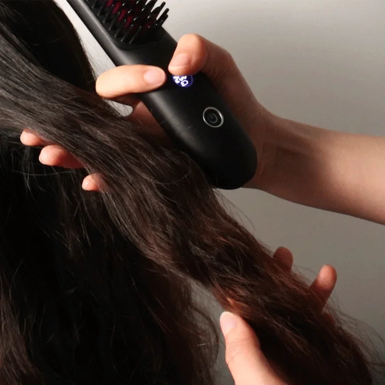 ヘアアイロンブラシ使用中の女性