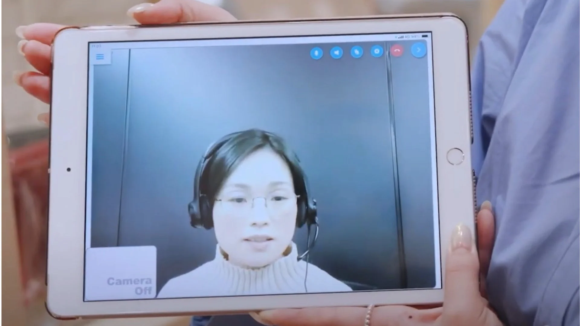 タブレット画面に表示されたビデオ通話中の女性