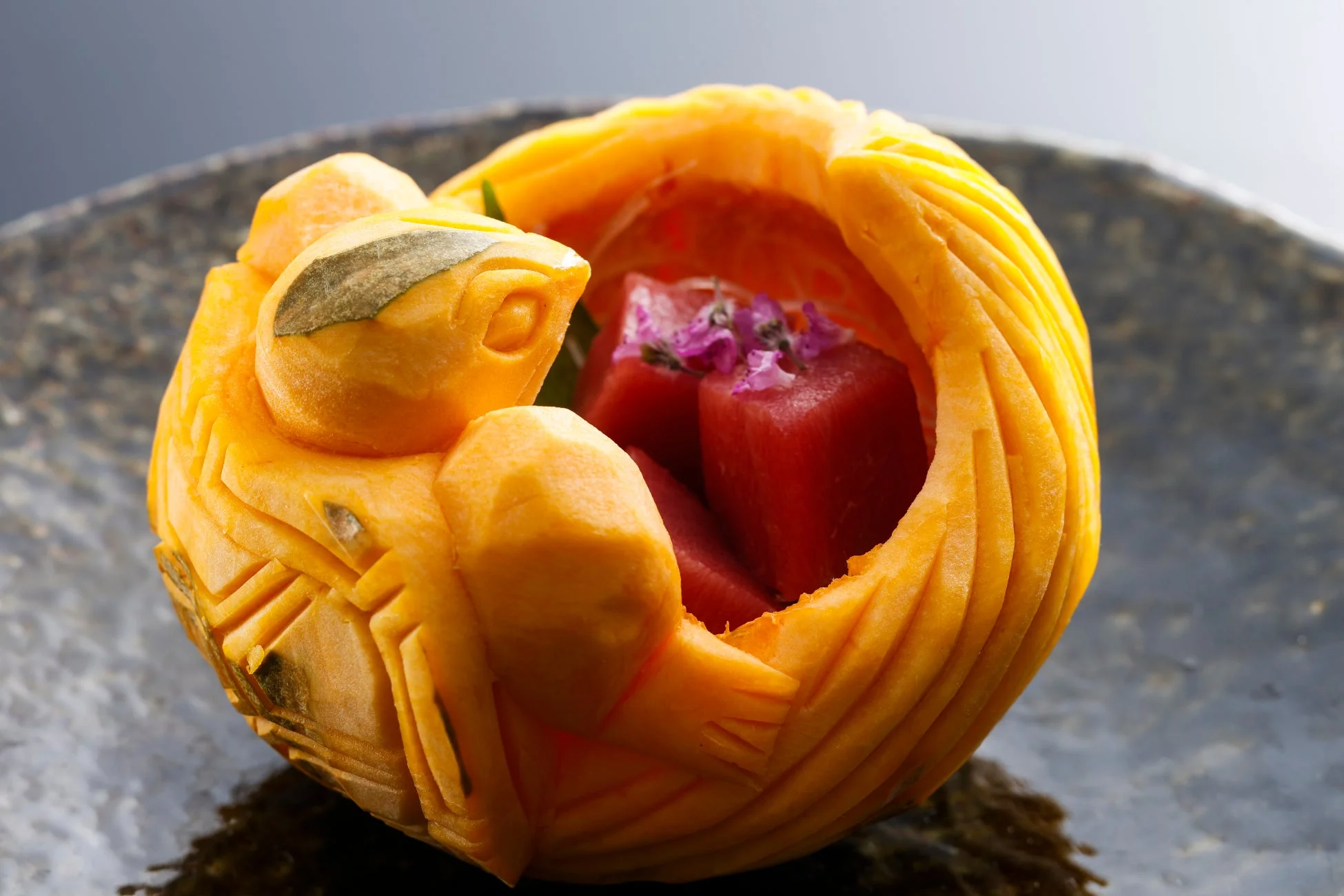 亀の形に彫られたフルーツの器に盛り付けられた料理