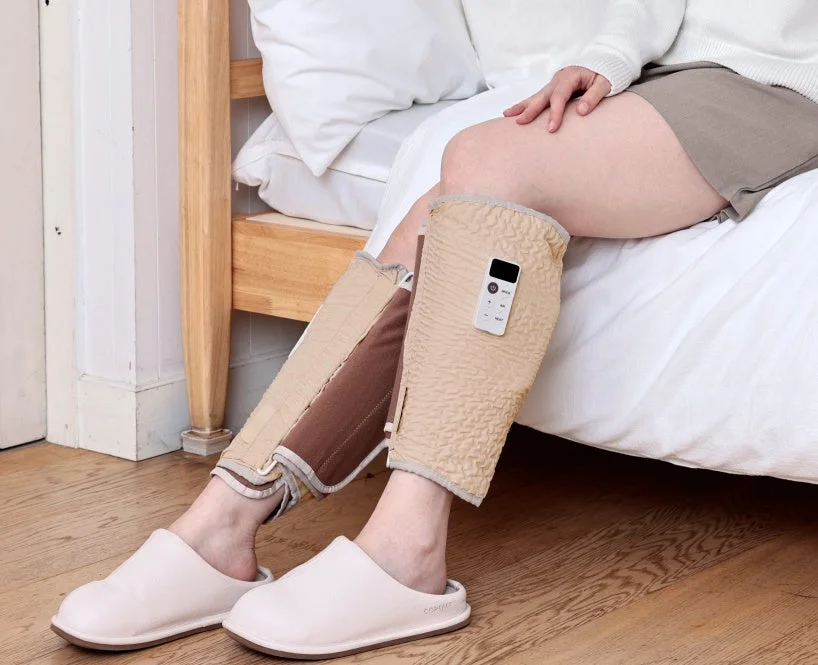 ベッドで脚用マッサージ器を使用しリラックスする人物