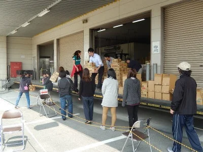 共同作業で段ボールを運ぶ人々