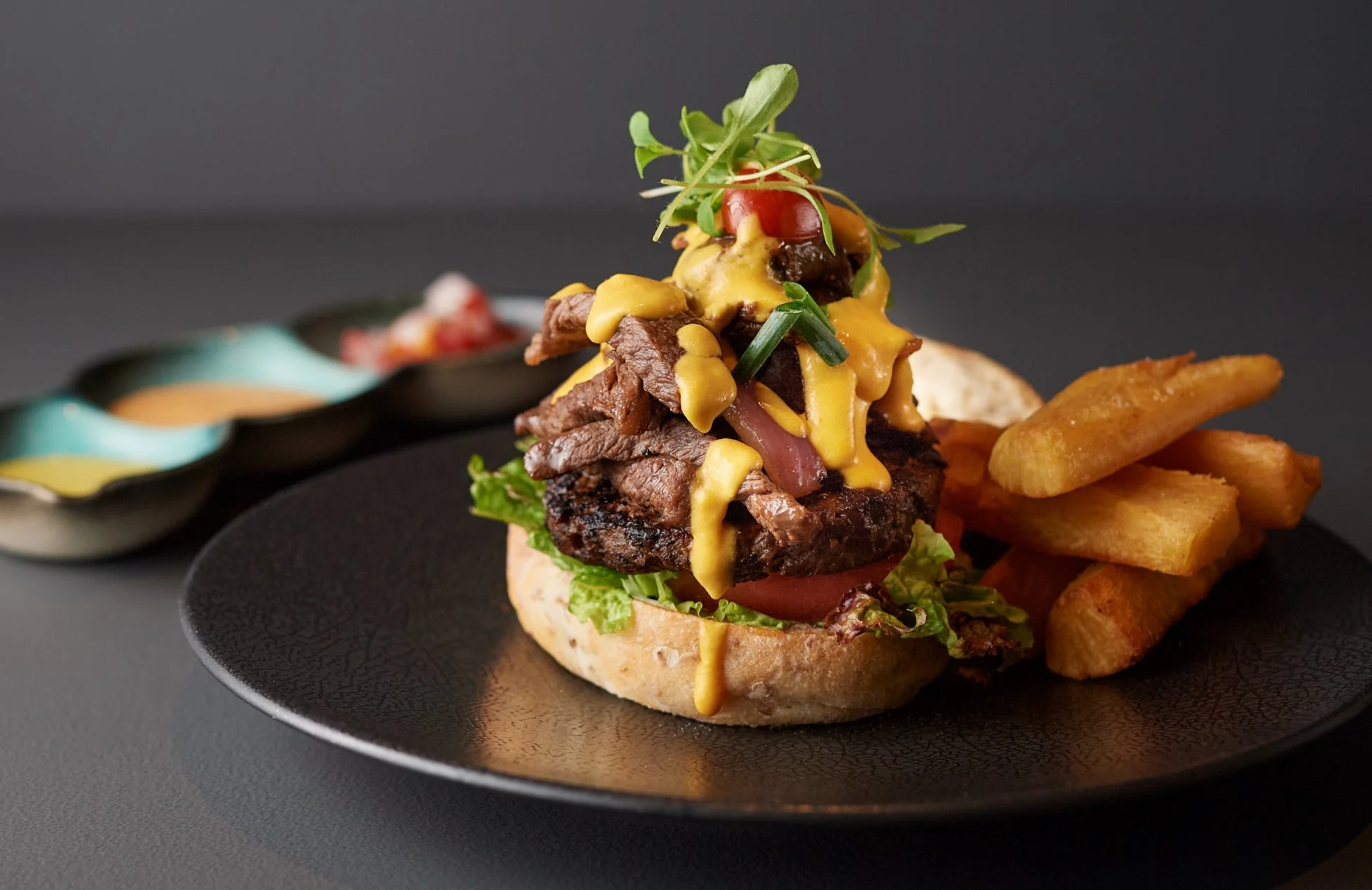 肉厚ステーキとチーズソースのハンバーガー、フライドポテト添え