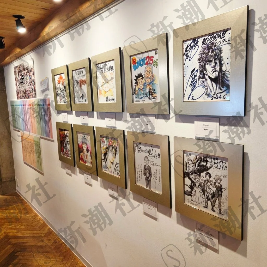 白い壁のギャラリーに額装された漫画イラストが多数展示されている