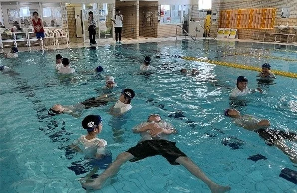 室内プールで水泳のレッスンを受ける子供たち