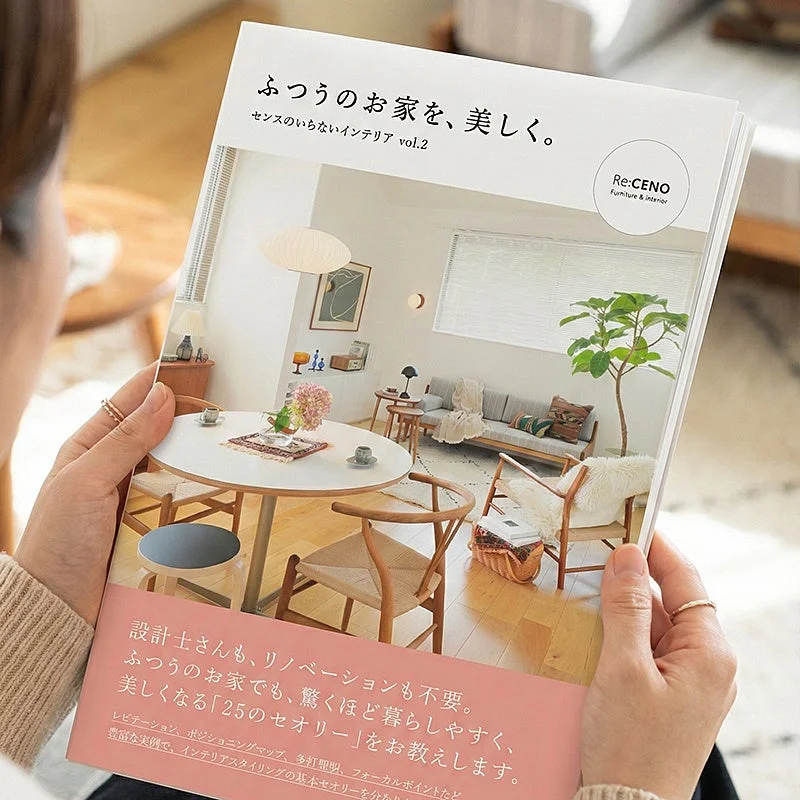書籍「ふつうのお家を、美しく。」を持つ女性