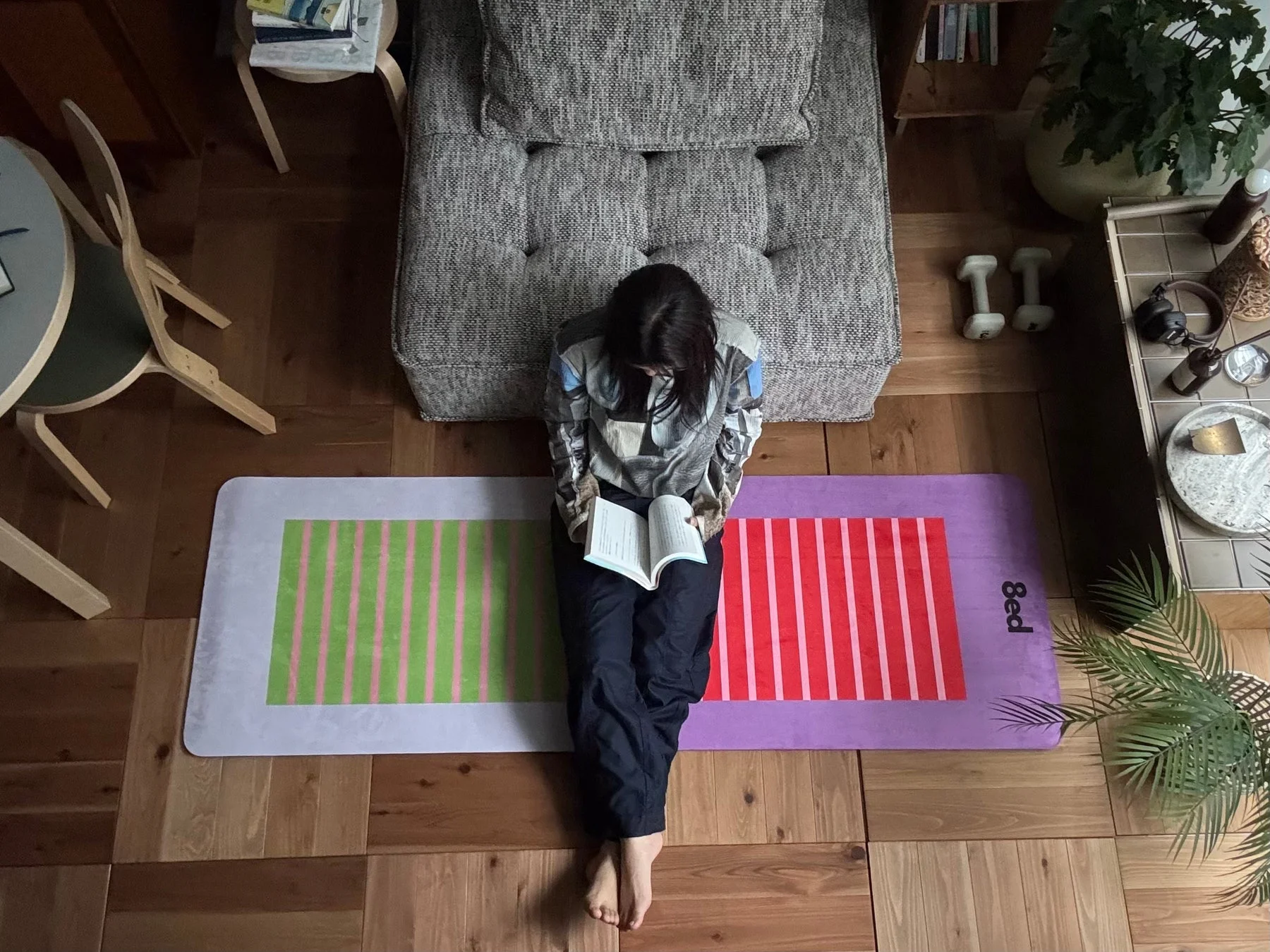 女性がマットの上で読書している画像