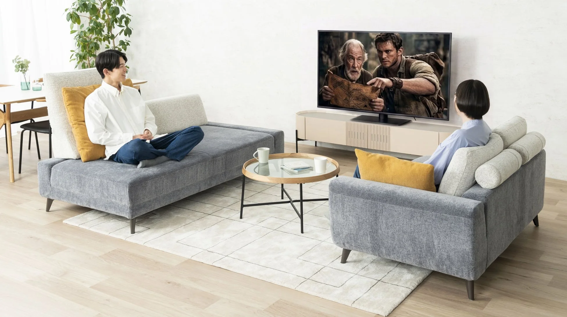 ソファでテレビを見るカップル