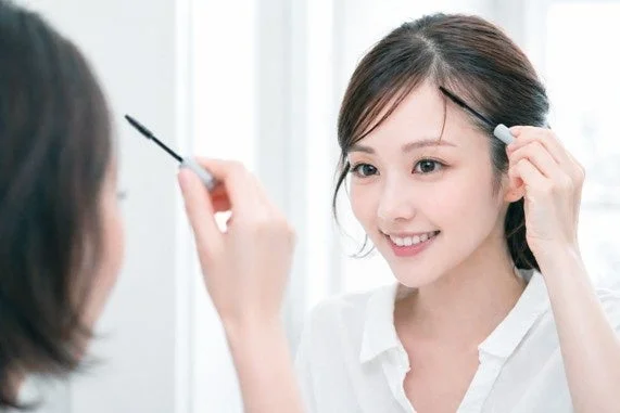 鏡を見ながらマスカラで整える女性