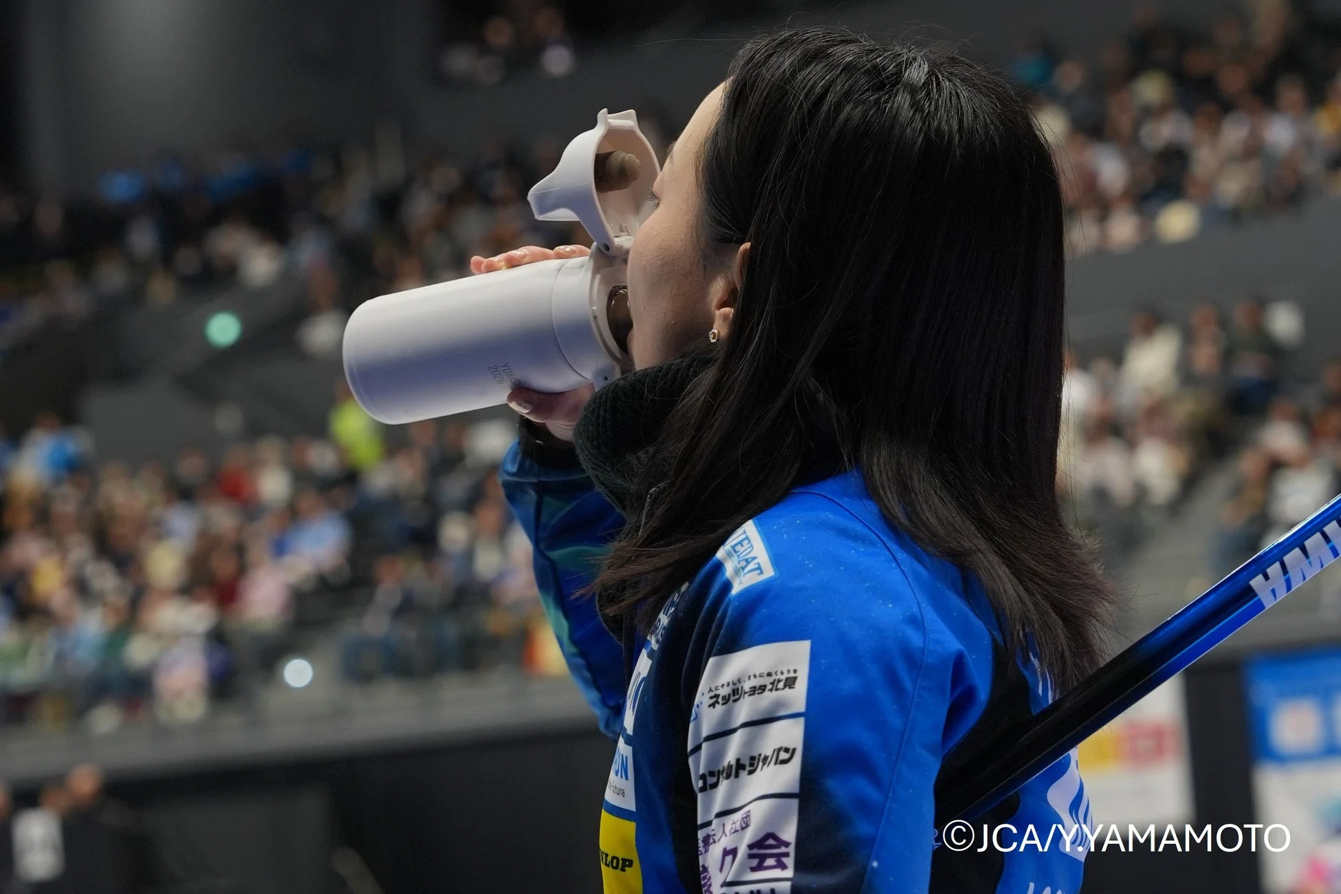 青いユニフォームの女性アスリートが水分補給