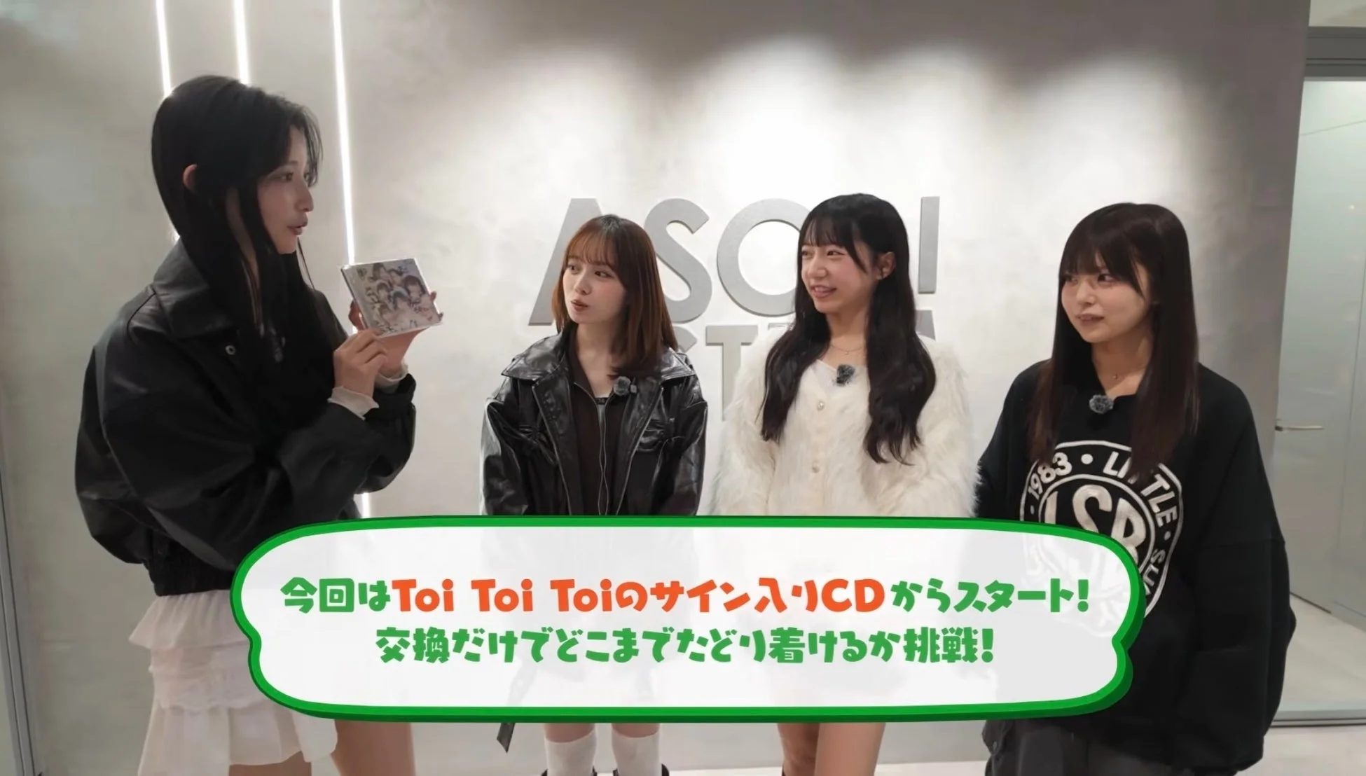 「Toi Toi Toiのサイン入りCD」を交換していくチャレンジ企画に臨む4人の女性アイドルグループの様子。一人がCDを手に持ち、期待に満ちた表情で企画の開始を告げている。