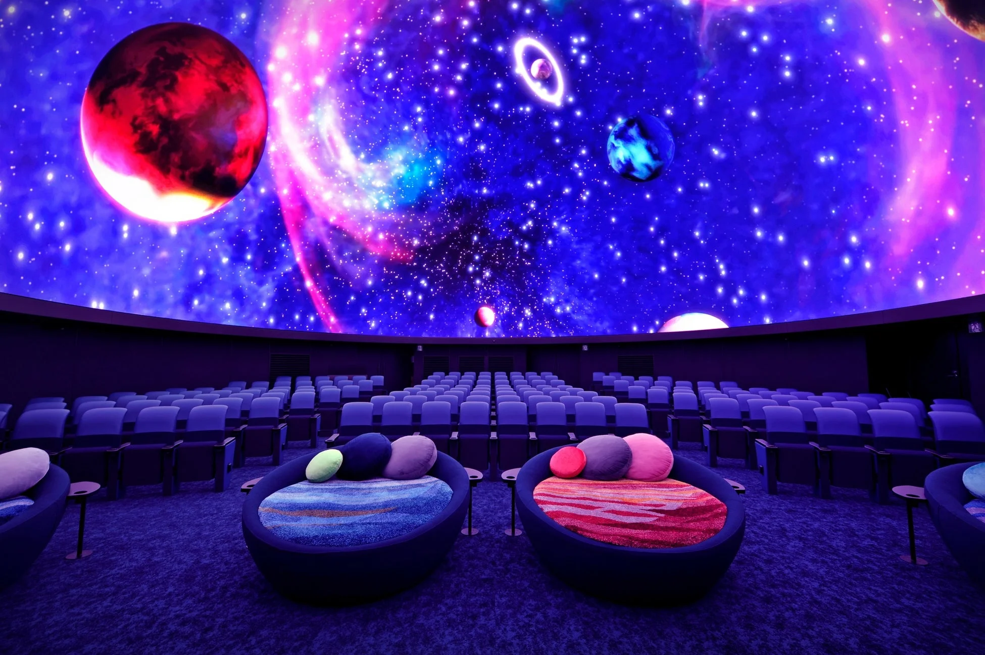 広々としたドーム型シアターで、鮮やかな宇宙の映像が天井に映し出されています。