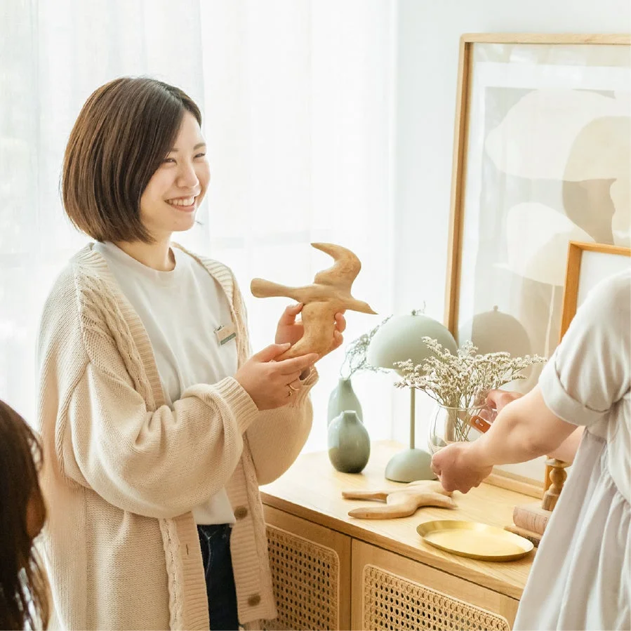 木彫りの鳥のオブジェを持つ女性