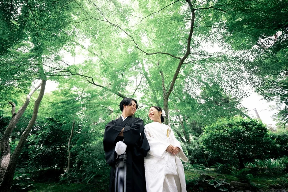 新緑の中で笑顔を見せる和装の新郎新婦