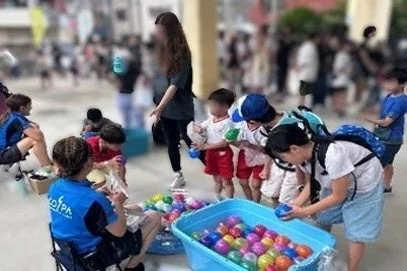 屋外イベントでボールすくいを楽しむ子供たち