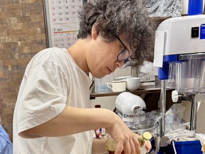 眼鏡をかけた男性が調理をしている場面
