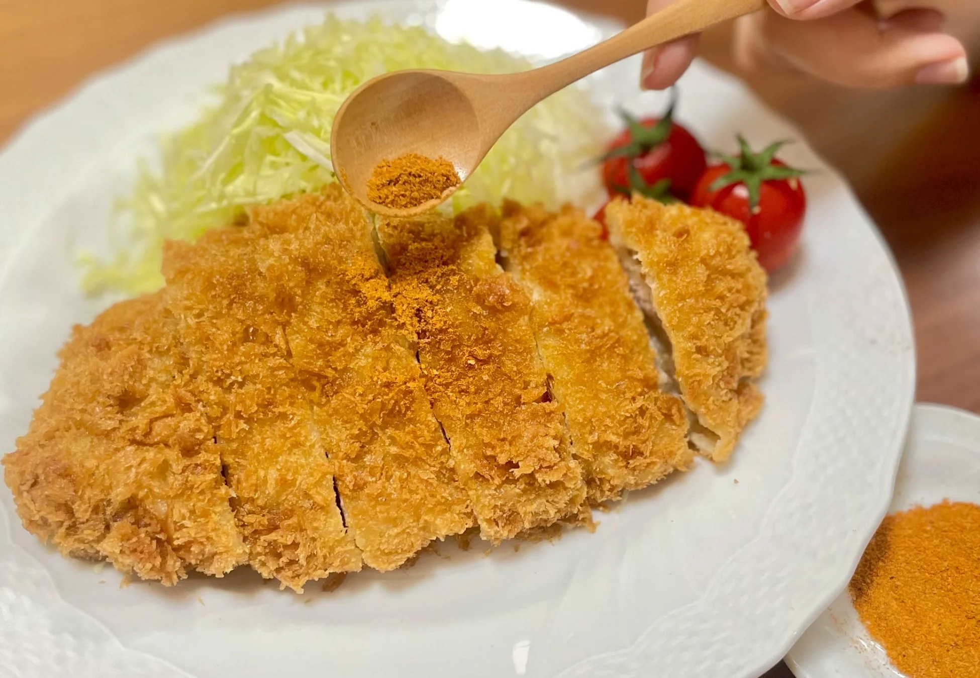 とんかつにスパイスを振りかける様子