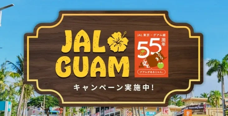 JALの東京-グアム線就航55周年を記念したキャンペーンの看板です。JALグアムのロゴと共に、ハイビスカスやチャモロ牛、ココナッツが描かれ、南国の雰囲気を伝えています。