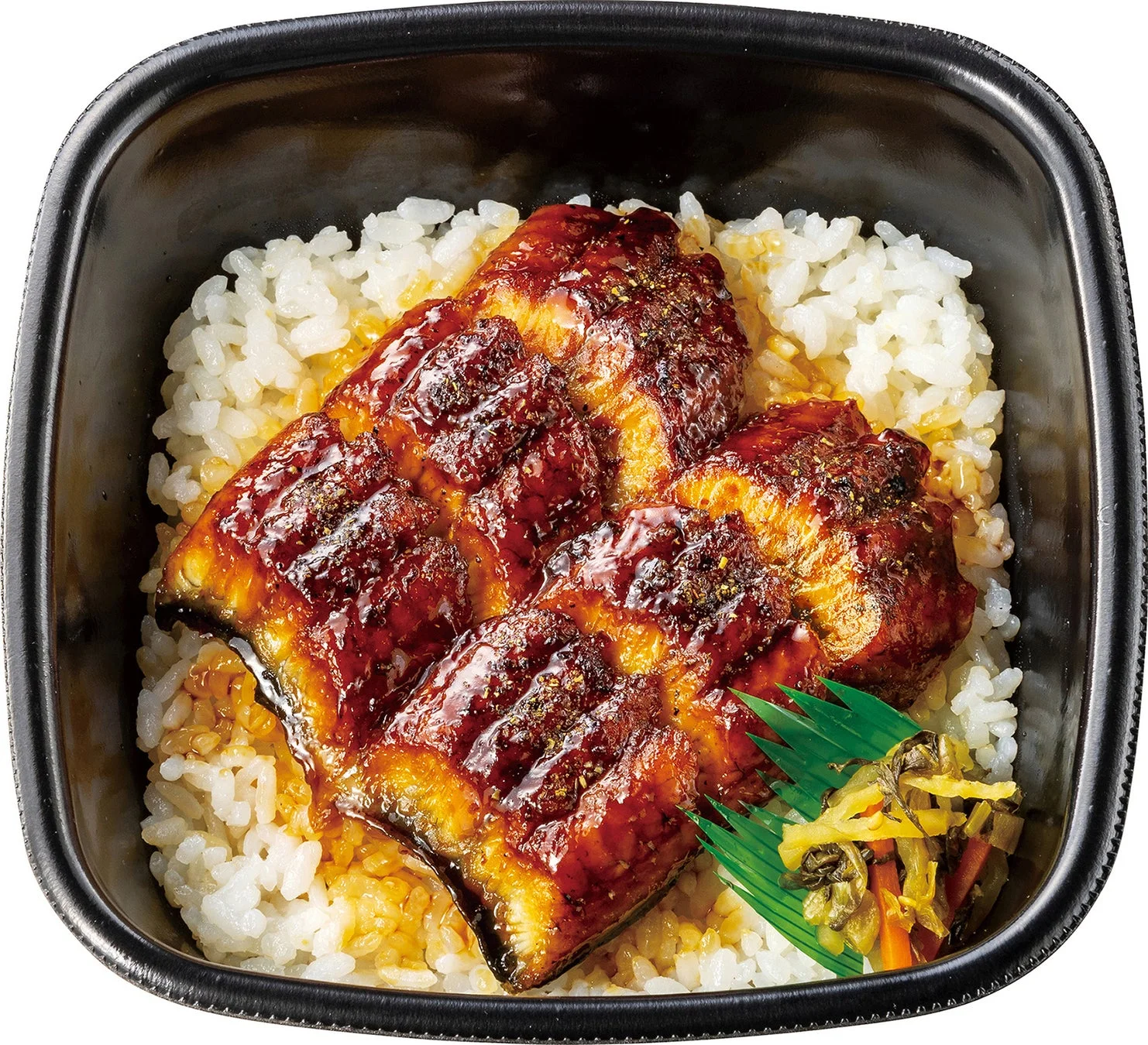 照り焼きのタレで香ばしく焼かれた鰻の蒲焼きがご飯の上に盛り付けられたうな丼です。山椒がかけられ、付け合わせの漬物も添えられています。