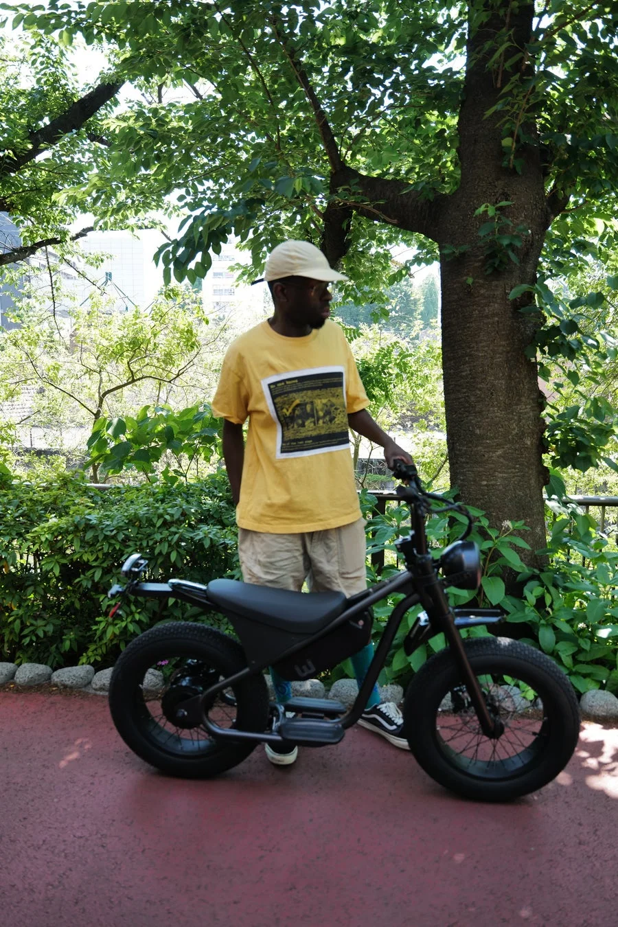 男性が電動自転車の隣に立っている様子