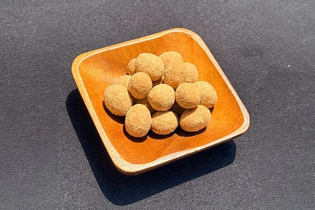 きな粉をまぶした丸いお菓子が木製の器に盛られている様子