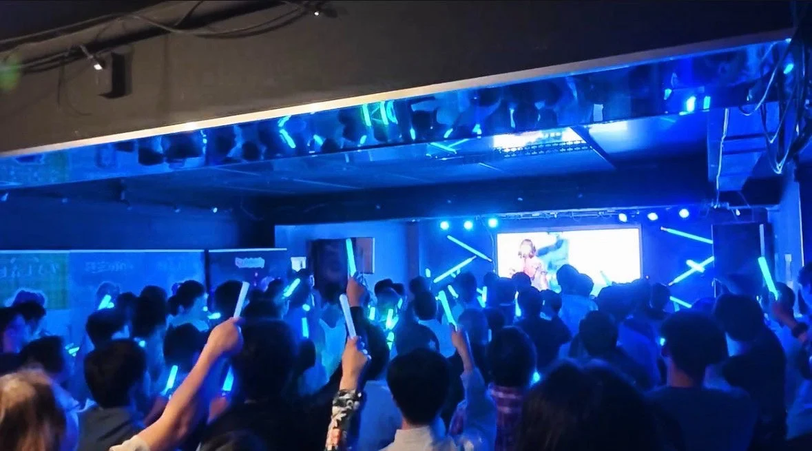 青いサイリウムを振るライブ観客