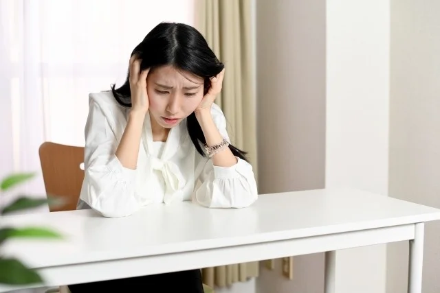 女性が頭を抱えている様子