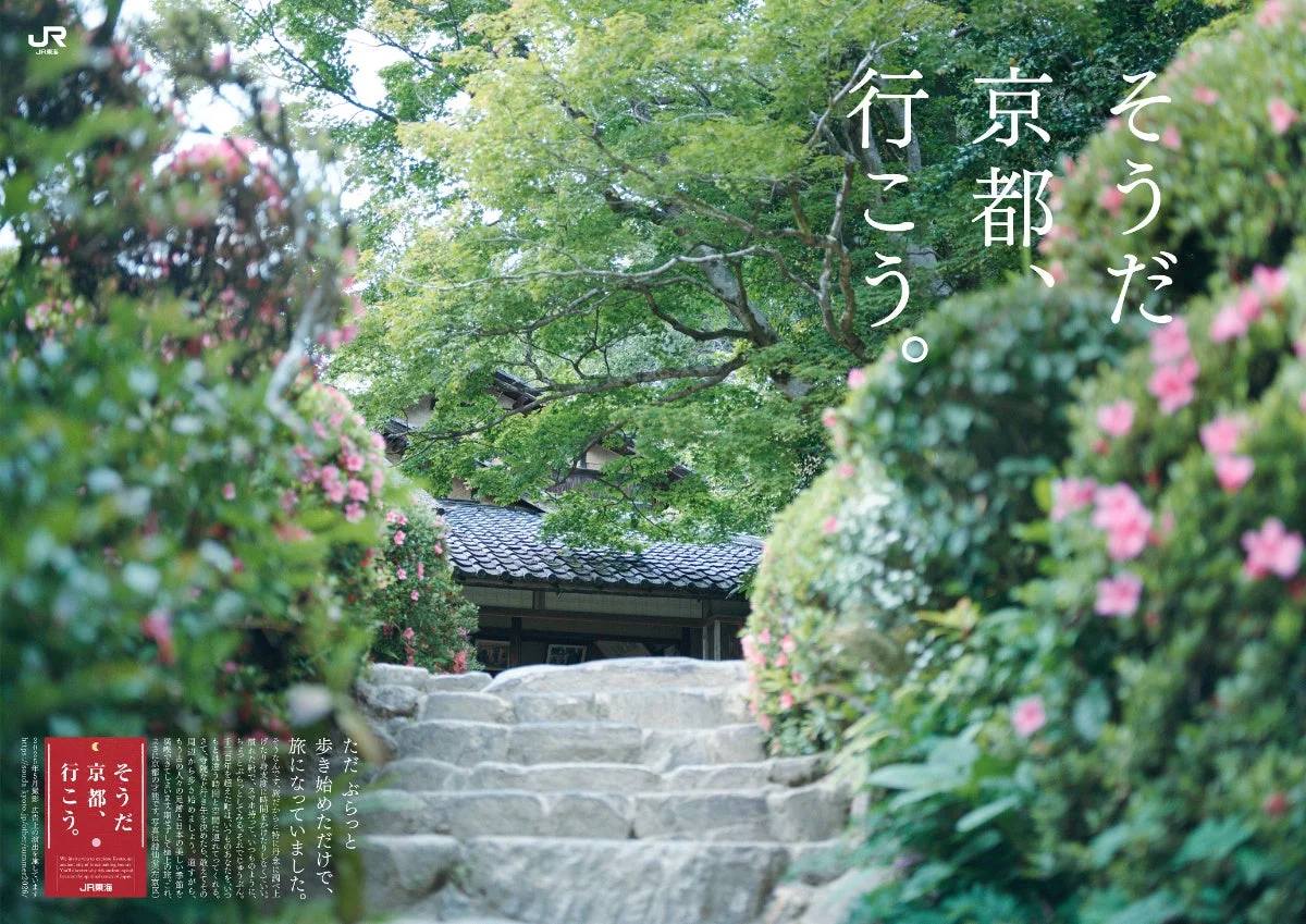 新緑とピンクの花に囲まれた石段の参道
