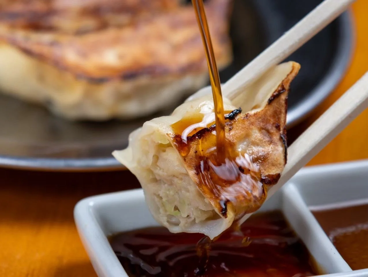 箸でつまんだ焼き餃子