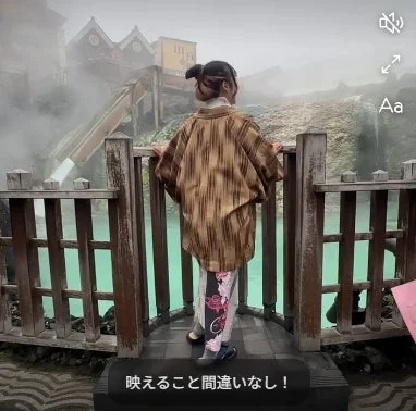 着物を着た人物が温泉地の景色を眺める