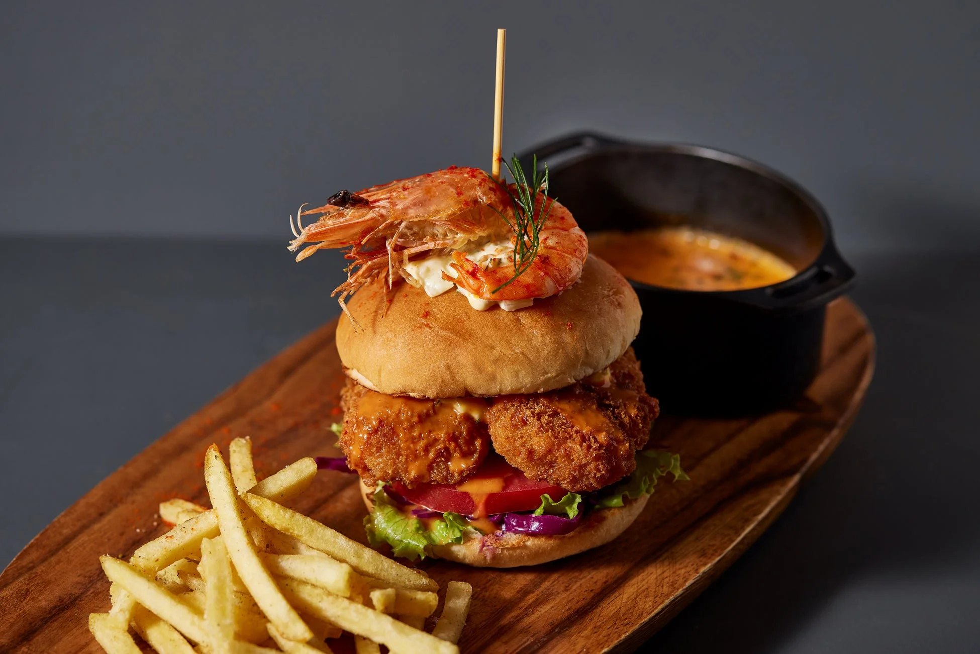 豪華なエビがトッピングされたハンバーガーとフライドポテトのセット
