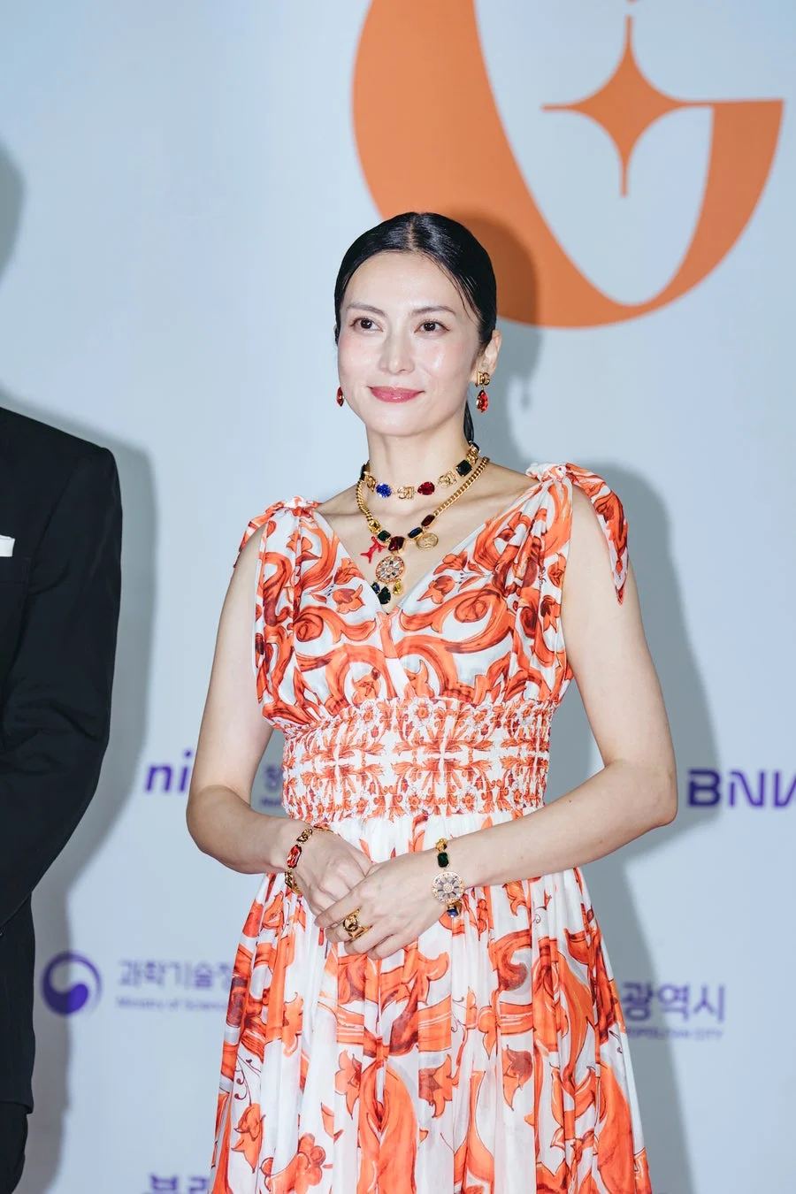 オレンジと白の柄物ドレスを着用した柴咲コウ氏