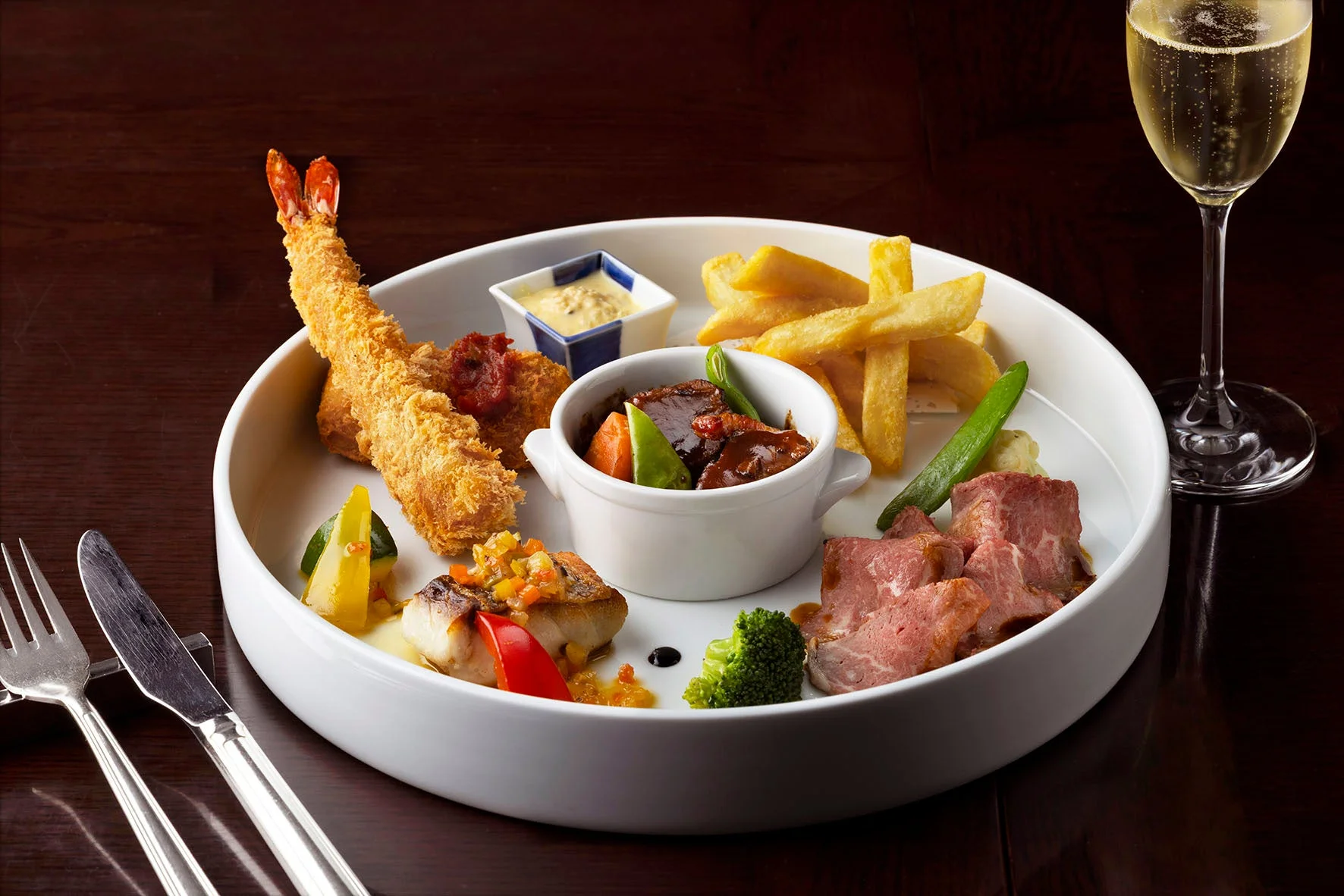 様々な洋食が豪華に盛り付けられたプレートとシャンパン
