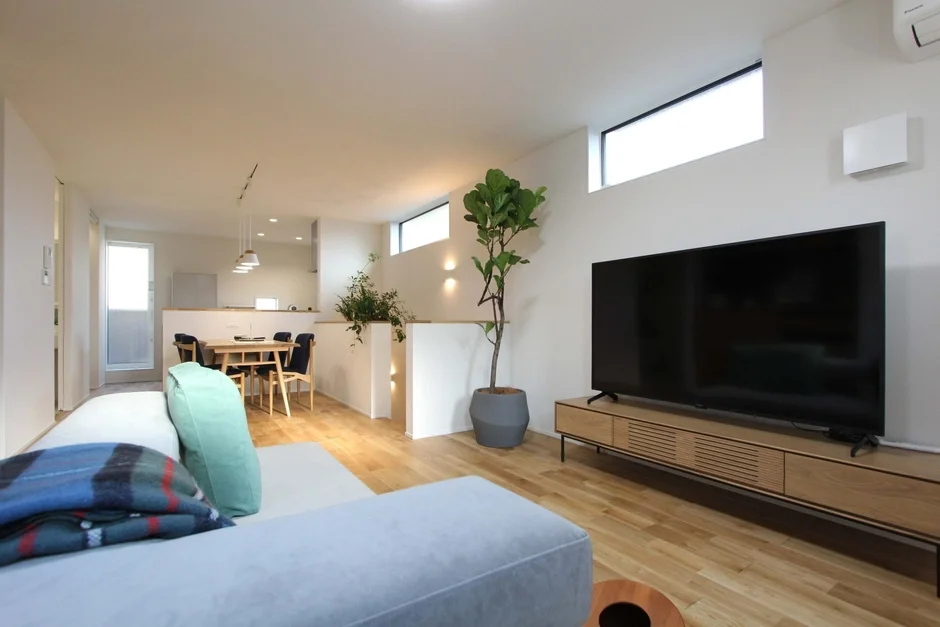 明るいリビングとダイニング、キッチンが一体となった現代的な住宅の室内風景