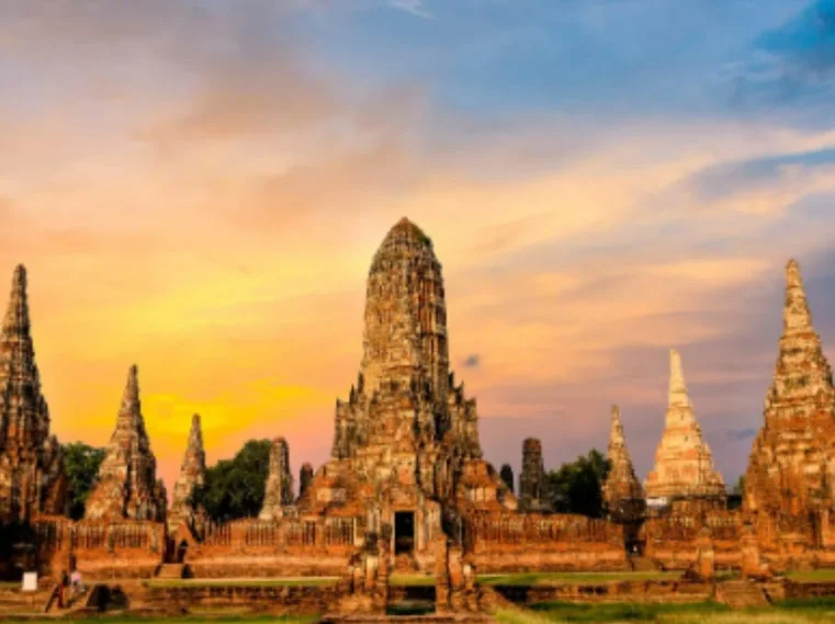 夕焼け空を背景に、タイのアユタヤにあるワット・チャイワッタナラム寺院の壮大な遺跡が写っています