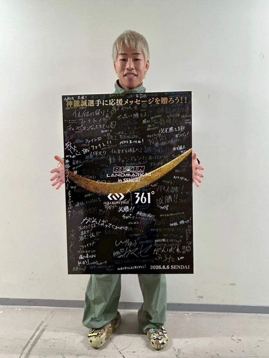 神龍誠選手への応援メッセージボードを掲げる男性