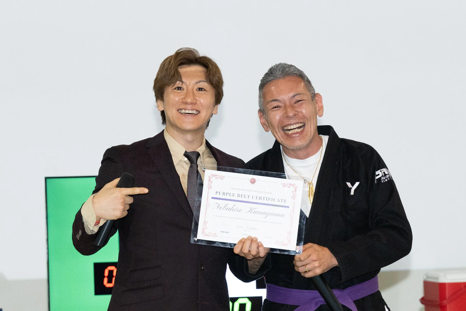 柔術の表彰式で紫帯認定書を持つ男性