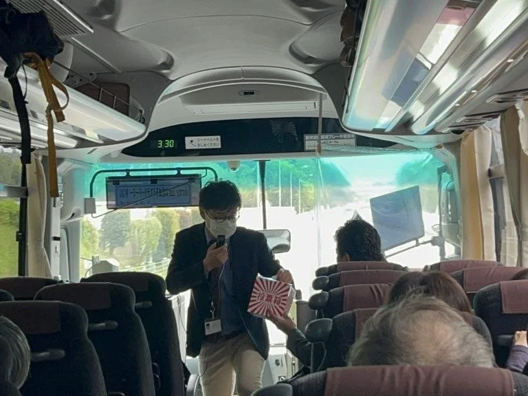 バス車内で説明するガイド