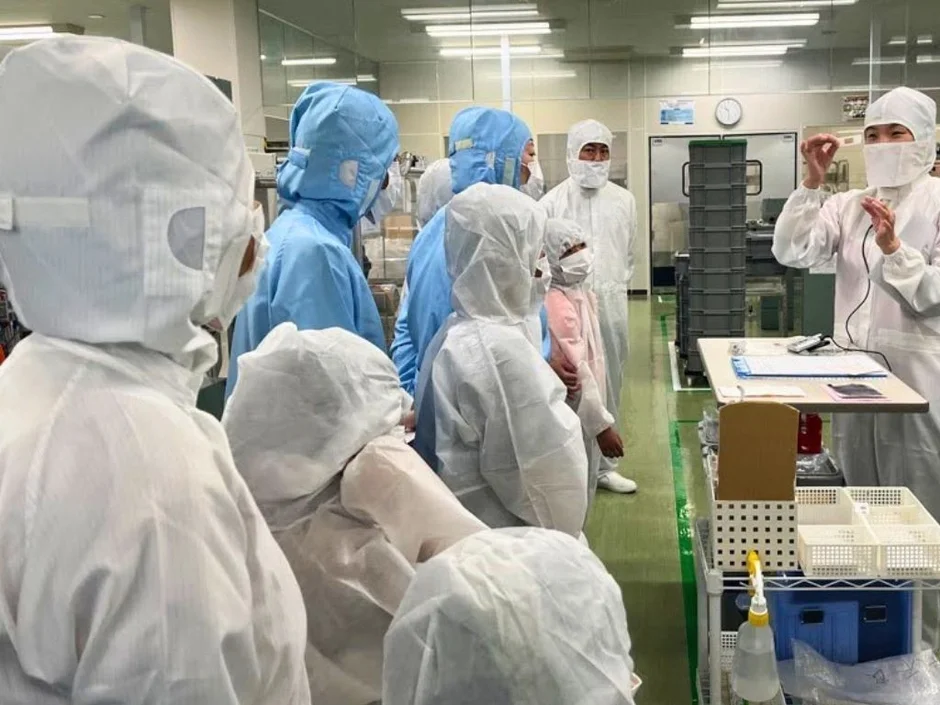 クリーンルーム内で説明を受ける人々