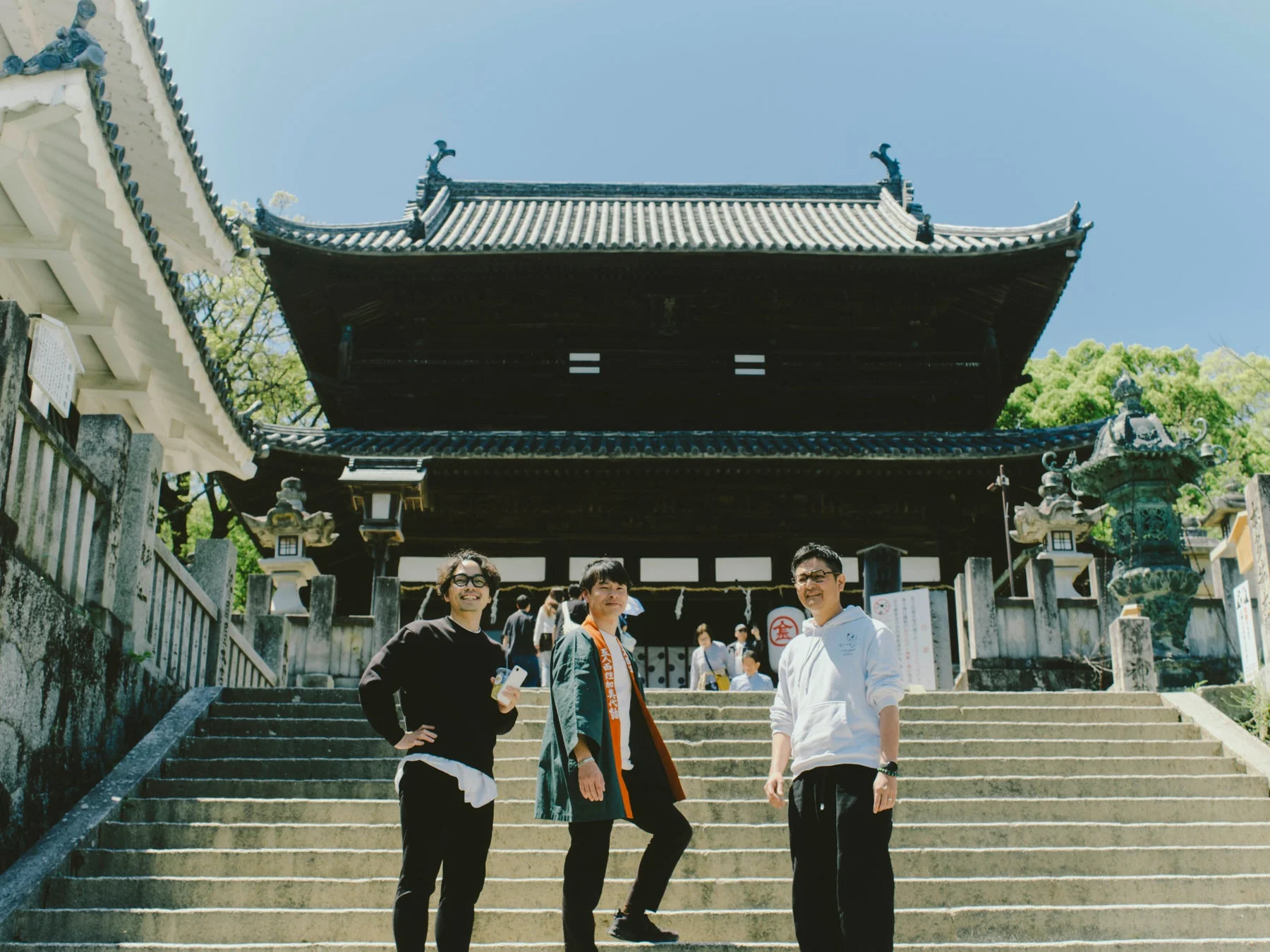 日本の伝統的な寺院の石段でポーズをとる3人の男性
