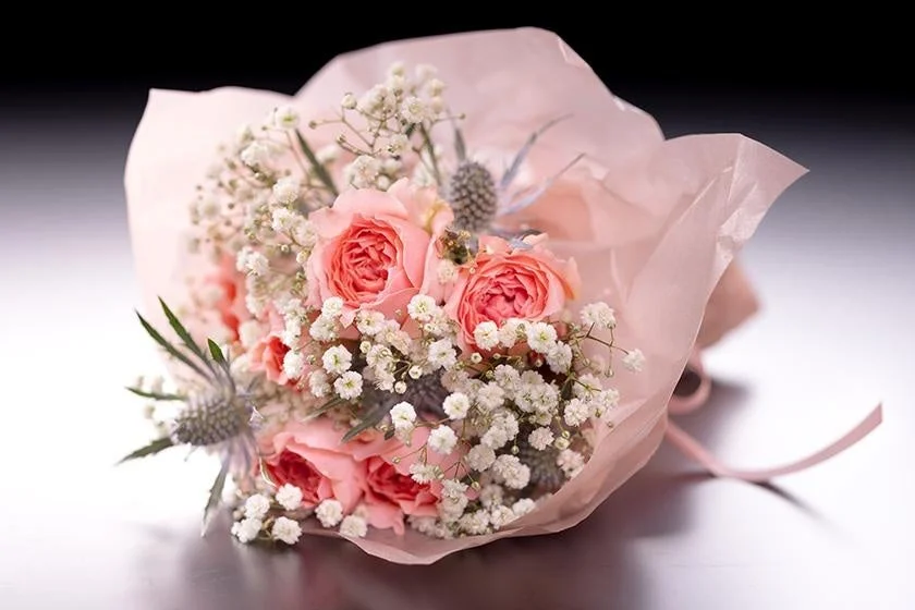 ピンク色のバラと白いかすみ草をメインにした、優しい雰囲気の花束です。