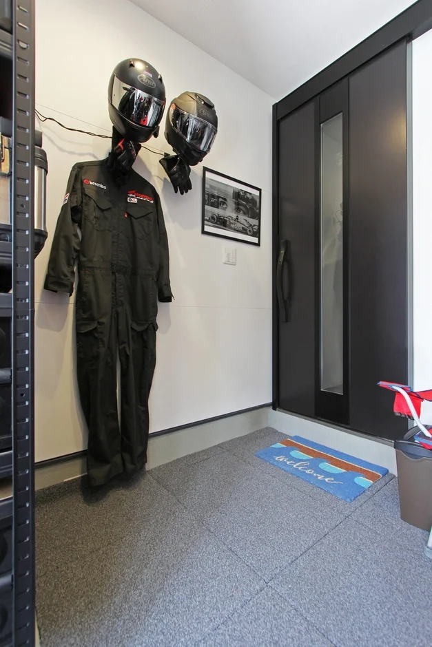 ガレージ内にディスプレイされたヘルメットとレーシングスーツ