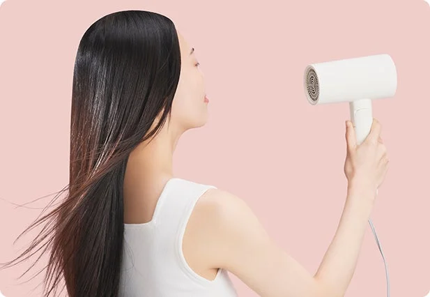 ヘアドライヤーを使う女性