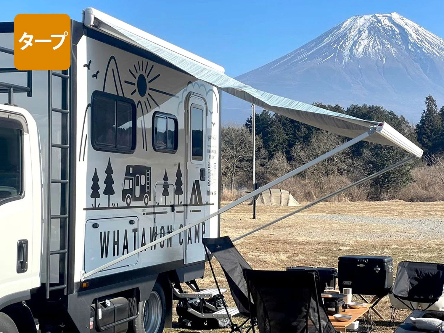 オーニングを広げ、キャンプを楽しむキャンピングカー