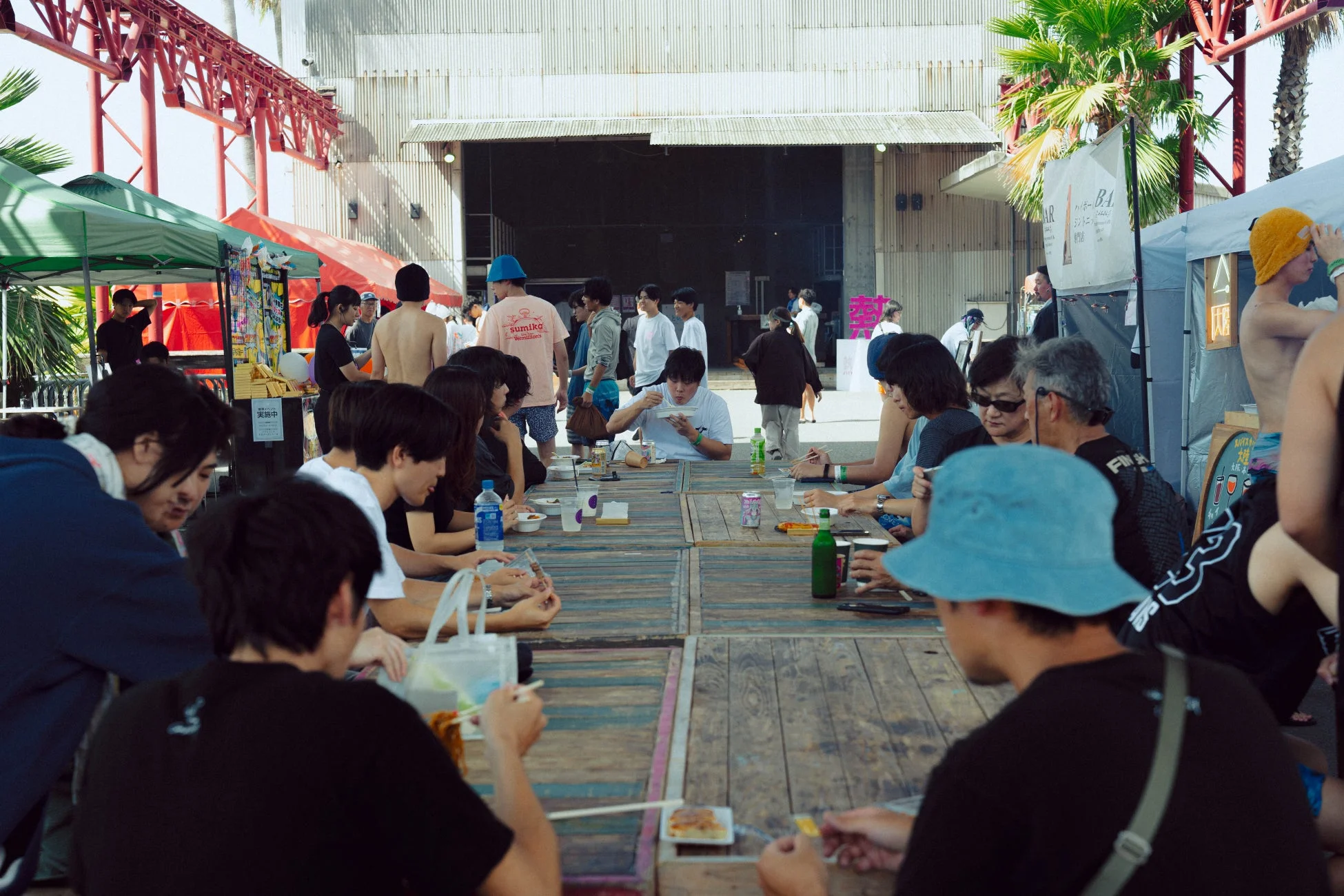 屋外イベントで食事や談笑を楽しむ人々