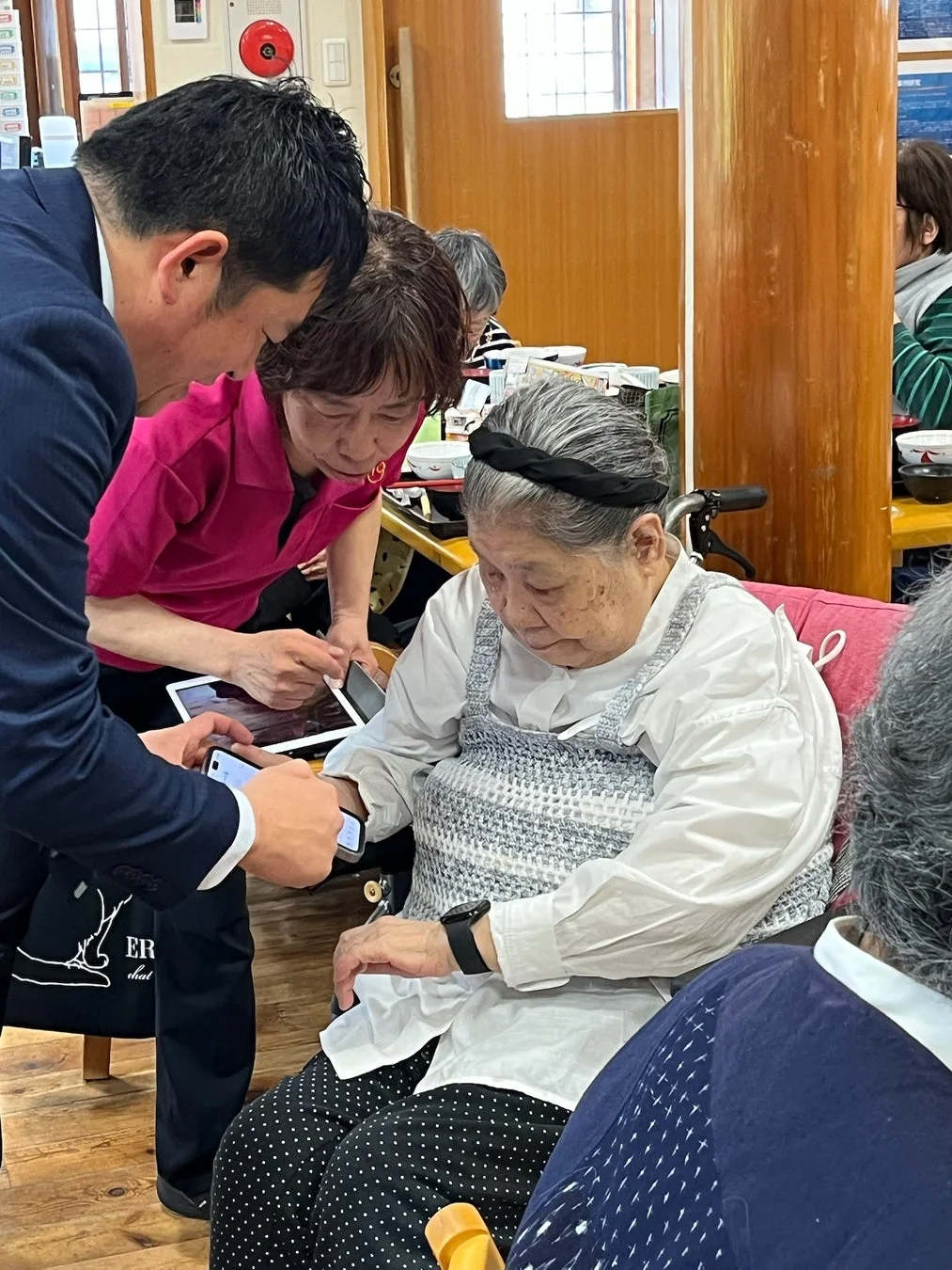 高齢者にデジタルデバイスの操作を教える人々