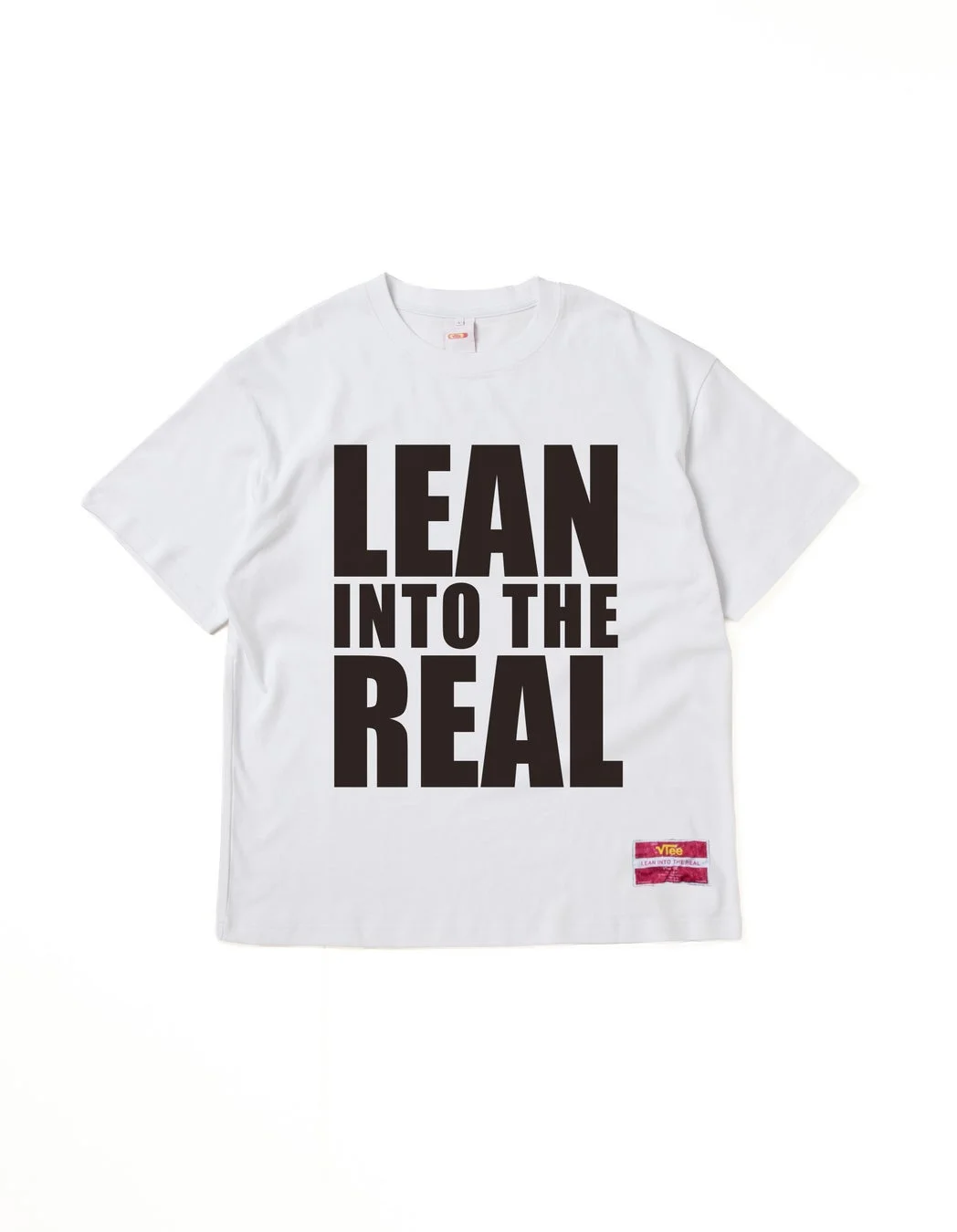 白いTシャツに「LEAN INTO THE REAL」とプリント