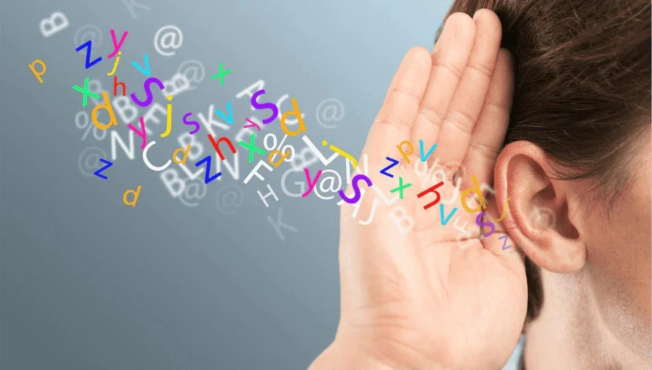 耳に手を当てて熱心に聞いている人物の側面が描かれており、様々な色や形の文字、記号が耳に向かって流れてくる様子は、情報や音を注意深く聞き取ろうとする行為や、情報収集の重要性を象徴しています。